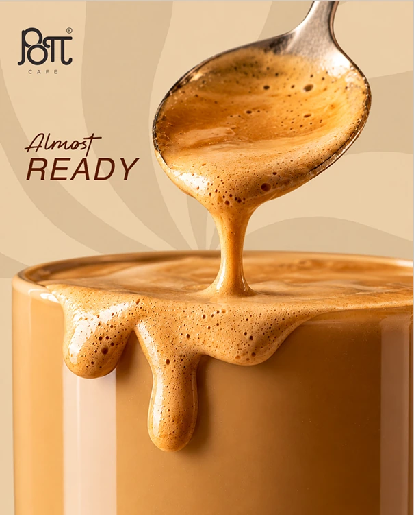 A spoon lifting thick golden coffee foam above a cup, with the words Almost Ready and the Pott Café logo