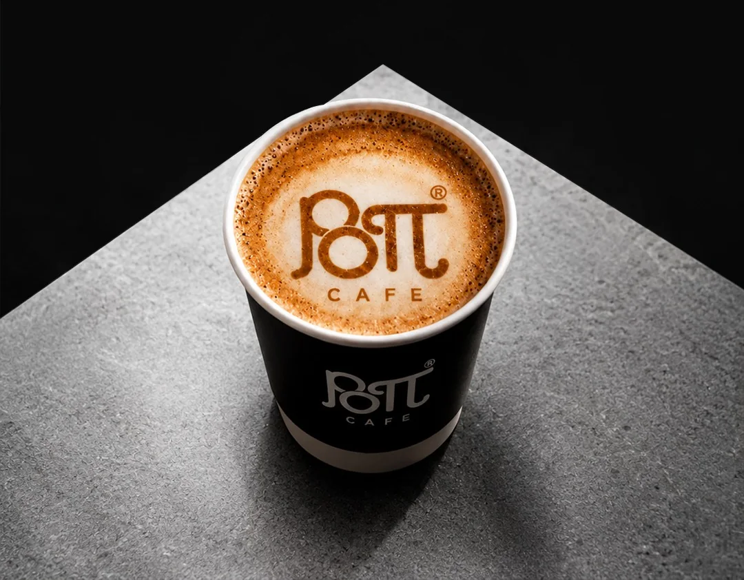 A cup of coffee with the Popeye Coffee logo in the foam